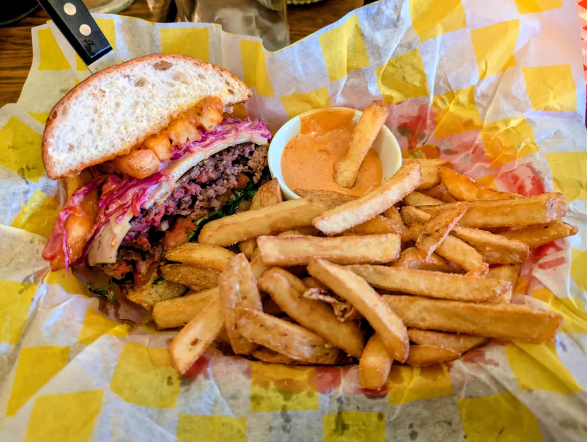 Burger cut in half with fresh-cut fries