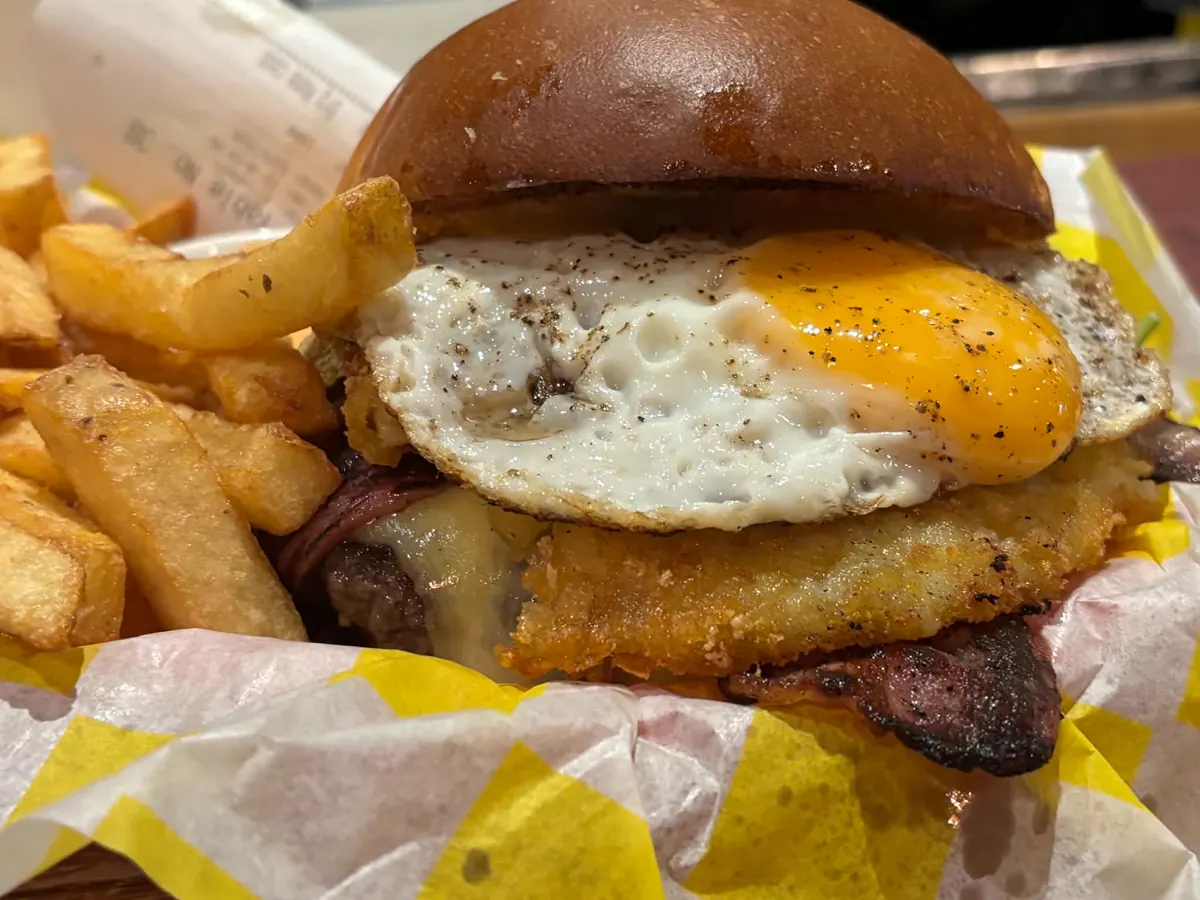 Burger with a fried egg and hash browns