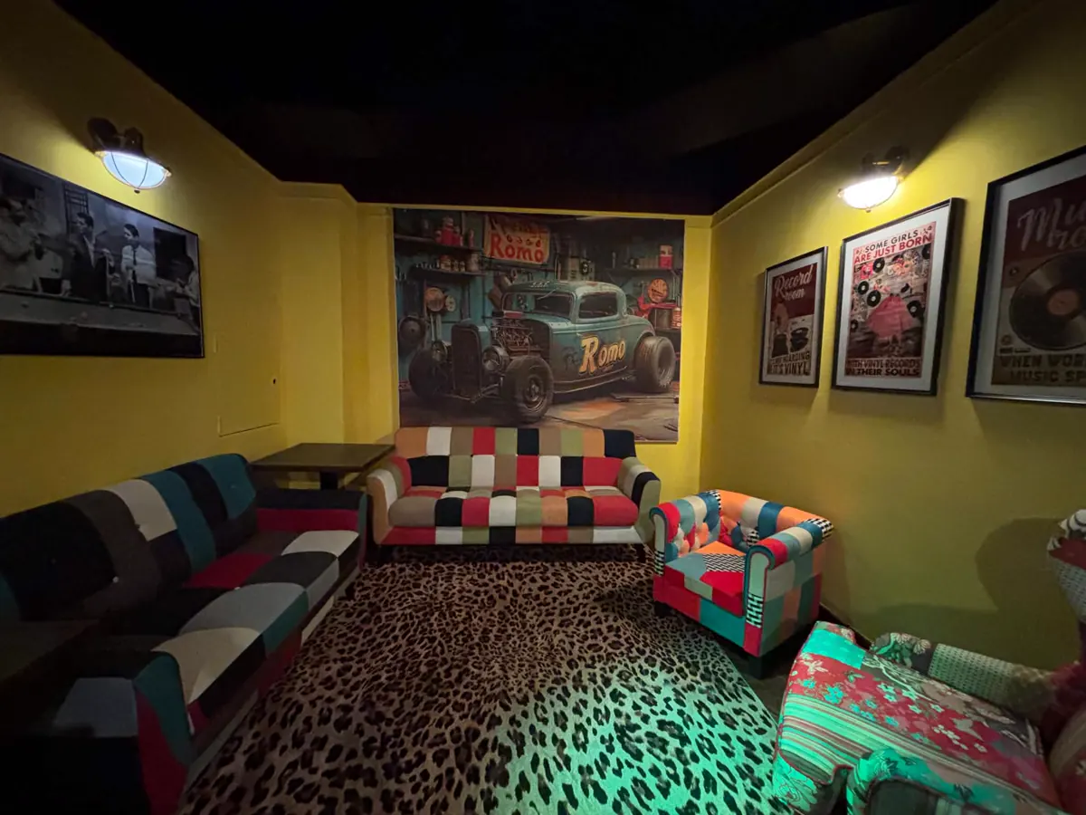 Lounge room with patchwork sofas and a hot-rod mural