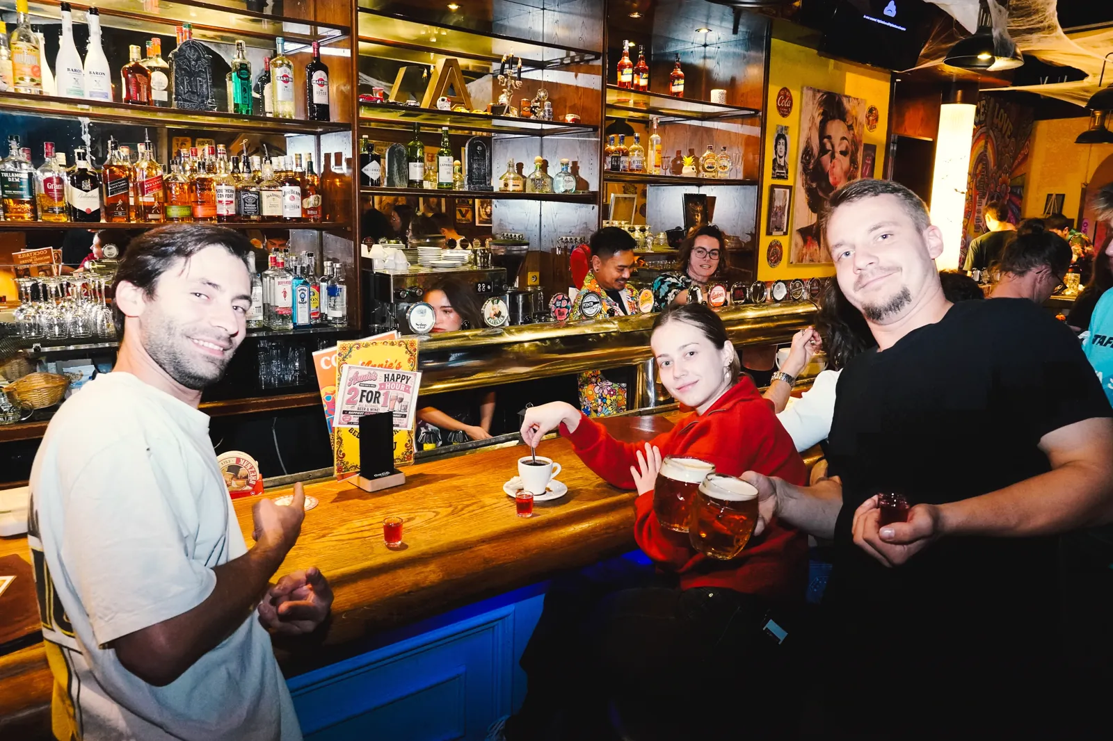 Hosté s pivem u baru během happy hour