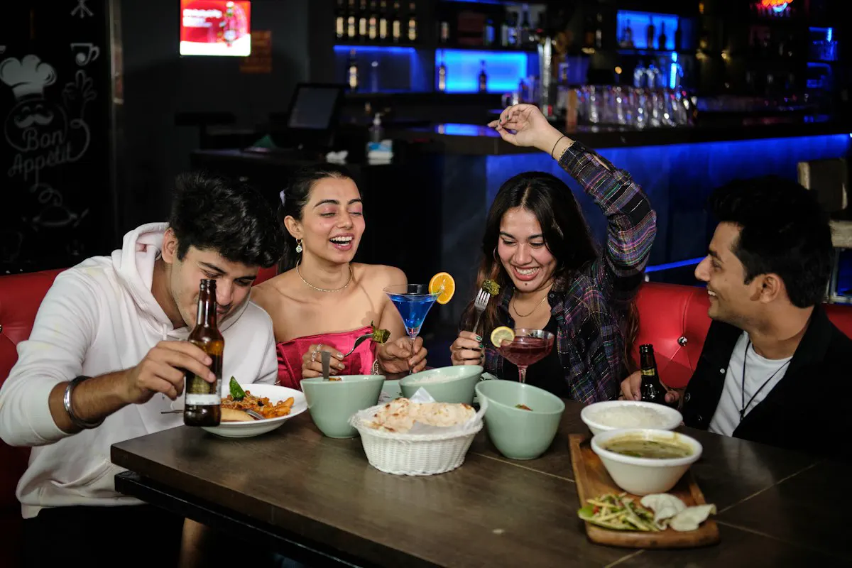 Group of friends eating and drinking around a table